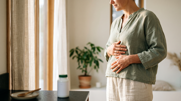 Pessoa com as mãos no abdómen, simbolizando conforto digestivo e equilíbrio da microbiota intestinal após os 40 anos