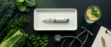 Caneta injetora médica sobre bandeja branca com vegetais frescos e estetoscópio — representação visual do tratamento médico supervisionado para perda de peso